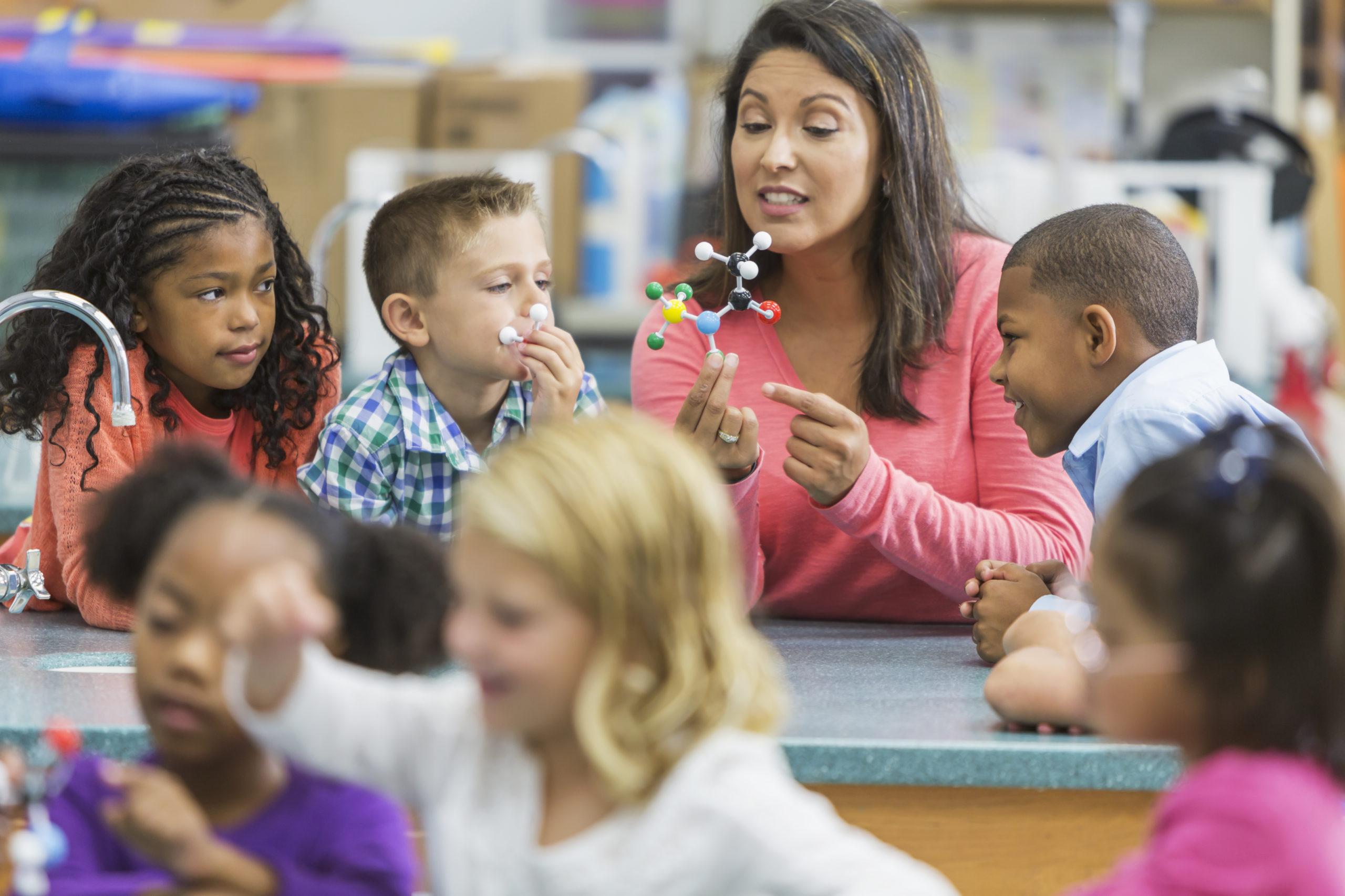 Young woman teaches elementary students about science